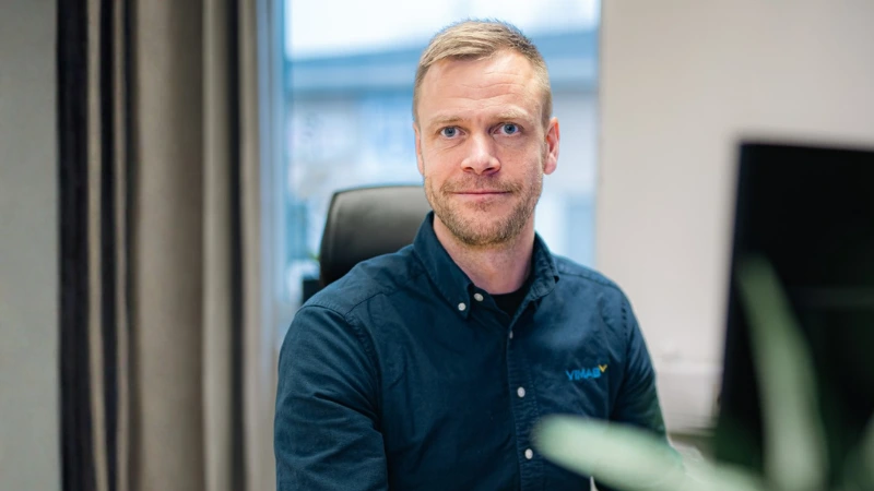 VIMAB-medarbetare i mörkblå skjorta med VIMAB-logotyp, fotograferad på kontor