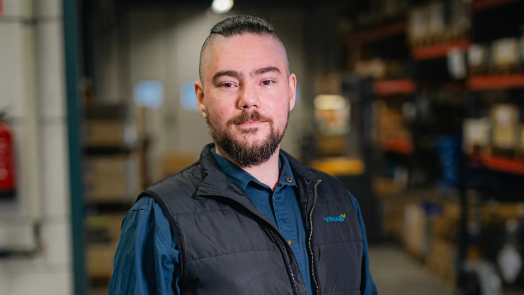 Edvin, ventiltekniker på VIMAB, i verkstadsmiljö med ventillager i bakgrunden