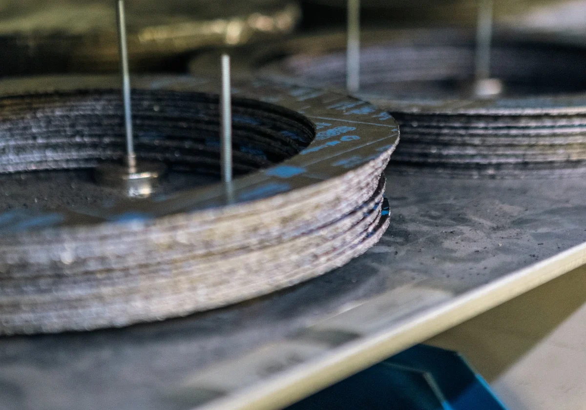 Ventildelar av metall staplade i verkstadsmiljö med vertikala stänger för sortering och inventering