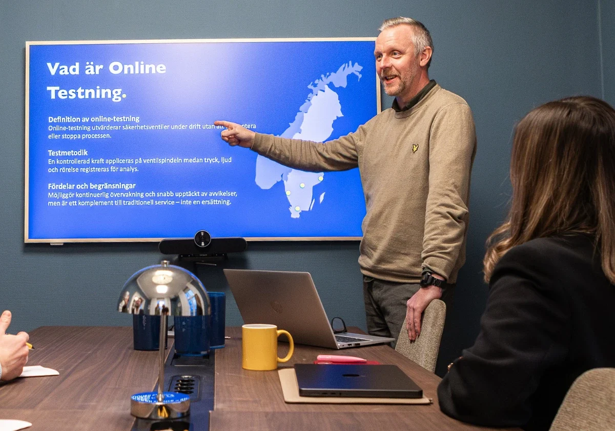 VIMAB-tekniker presenterar online-testning av ventiler för deltagare vid konferensbord med laptop och skärm